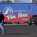 
              A pedestrian crosses the street in Van Horn, Texas, Monday, Oct. 11, 2021. Tuesday's Blue Origin launch near the city has been pushed to Wednesday due to weather. (AP Photo/LM Otero)
            