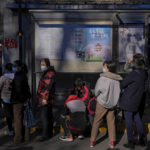 
              Residents wearing face masks to help curb the spread of the coronavirus line up to receive booster shots against COVID-19 at a vaccination site with a billboard displaying a propaganda poster supporting the Beijing 2022 Winter Olympic Games, near a residential area in Beijing, Friday, Oct. 22, 2021. China's capital Beijing has begun offering booster shots against COVID-19, four months before the city and surrounding regions are to host the Winter Olympics. (AP Photo/Andy Wong)
            