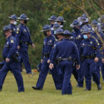 
              FILE - In this Friday, Sept. 25, 2020, file photo, troopers of the Louisiana State Police gather at the burial site of Master Trooper Chris Hollingsworth, in West Monroe, La. Hollingsworth died in a single-car crash hours after he learned he had been fired for his role in the in-custody death of Ronald Greene. As the Louisiana State Police reel from a sprawling federal investigation into the deadly 2019 arrest of Greene, a Black motorist, and other beating cases, dozens of current and former troopers tell The Associated Press of an entrenched culture at the agency of impunity, nepotism and in some cases outright racism. (AP Photo/Rogelio V. Solis, File)
            