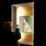 
              A woman takes a photo of Gustav Klimt's oil on canvas painting "Portrait of a Lady" (1916/17) on display at the exhibition "Klimt. The Secession and Italy" at the Museum of Rome, in Palazzo Braschi, Rome, during a press preview, Tuesday, Oct. 26, 2021. The exhibition, that explores Klimt's period in Italy, will be open to visitors from Oct.27, 2021 to March 27, 2022. (AP Photo/Andrew Medichini)
            