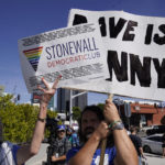 
              Jane Wishon, Political Vice President of the Stonewall Democratic Club, left, holds a sign in front of an unidentified demonstrator supporting Dave Chappelle, outside the Netflix building in the Hollywood section of Los Angeles, Wednesday, Oct. 20, 2021. Critics and supporters of Chappelle's Netflix special and its anti-transgender comments gathered outside the company's offices Wednesday. (AP Photo/Damian Dovarganes)
            