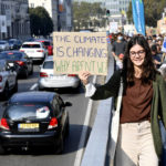 
              A girl holds up a sign to oncoming traffic as she participates in a climate march and demonstration in Brussels, Sunday, Oct. 10, 2021. Some 80 organizations are joining in a climate march through Brussels to demand change and push politicians to effective action in Glasgow later this month.(AP Photo/Geert Vanden Wijngaert)
            