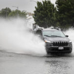 
              A vehicle negotiates standing water along Riverside drive in Toluca Lake, Calif., Monday, Oct. 25, 2021. Heavy rain moving down from Northern California is expected to hit the Los Angeles area today. (David Crane/The Orange County Register via AP)
            