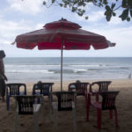
              A beach vendor sets chairs as he waits for customers in Kuta beach in Bali, Indonesia, Thursday, Oct. 14, 2021. The Indonesian resort island of Bali welcomed international travelers to its shops and white-sand beaches for the first time in more than a year Thursday - if they're vaccinated, test negative, hail from certain countries, quarantine and heed restrictions in public. (AP Photo/Firdia Lisnawati)
            