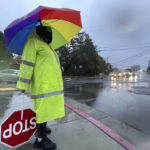 
              Crossing guard Katy Bredahl is pelted with rain while keeping an eye out for children on Marinwood Avenue in San Rafael, Calif., on Thursday, Oct. 21, 2021. Northern California residents delighted by this week's rain were cleaning up Friday and preparing for a massive storm this weekend, happy the precipitation has helped contain stubborn wildfires but fearful of flash flooding in vast areas already scorched by fire. (Sherry LaVars/Marin Independent Journal via AP)
            