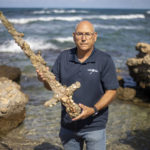 
              Jacob Sharvit, director of the Marine Archaeology Unit of the Israel Antiquities Authority holds a meter-long (yard-long) sword, that experts say dates back to the Crusaders is on display in Mediterranean seaport of Cesarea, Israel, Tuesday, Oct. 19, 2021. Israeli archaeologists say a scuba diver has salvaged an ancient sword off the country's Mediterranean coast that experts say dates back to the Crusaders. Israel's Antiquities Authority said Monday the man was on a weekend dive in northern Israel last Saturday when he spotted a trove of ancient artifacts that included anchors, pottery and a meter-long (yard-long) sword. Fearing the sword would be covered up by shifting sands, it says the man took it ashore and handed it over to government experts. Archaeologists believe that many ancient treasures are submerged in the area. The diver was given a certificate of appreciation for turning over the 900-year-old item. (AP Photo/Ariel Schalit)
            