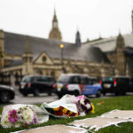 
              Flowers are placed as a tribute in Parliament Square following Friday's death of member of Parliament David Amess in Leigh-on-Sea, Essex, in London, Saturday, Oct. 16, 2021. Leaders from across the political spectrum came together Saturday to pay tribute to a long-serving British lawmaker who was stabbed to death in what police have described as a terrorist incident. (Aaron Chown/PA via AP)
            