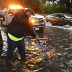 
              Anthony Flores, with the City of Clovis, works to clear a storm drain on Monday, Oct. 25, 2021, in Clovis, Calif. A massive storm barreled toward Southern California on Monday after flooding highways, toppling trees, cutting power to about 380,000 utility customers and causing rock slides and mud flows in areas burned bare by wildfires across the northern half of the state. (John Walker/Fresno Bee via AP)
            