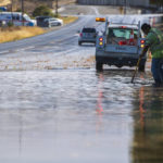 
              A member of Hollister's Department of Public Works clears floodwaters on Hillcrest Road in Hollister, Calif., Monday, Oct. 25, 2021. (AP Photo/Nic Coury)
            