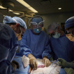 
              In this September 2021 photo provided by NYU Langone Health, a surgical team at the hospital in New York examines a pig kidney attached to the body of a deceased recipient for any signs of rejection. From left are Drs. Zoe A. Stewart-Lewis, Robert A. Montgomery, Bonnie E. Lonze and Jeffrey Stern. The test was a step in the decades-long quest to one day use animal organs for life-saving transplants. (Joe Carrotta/NYU Langone Health via AP)
            