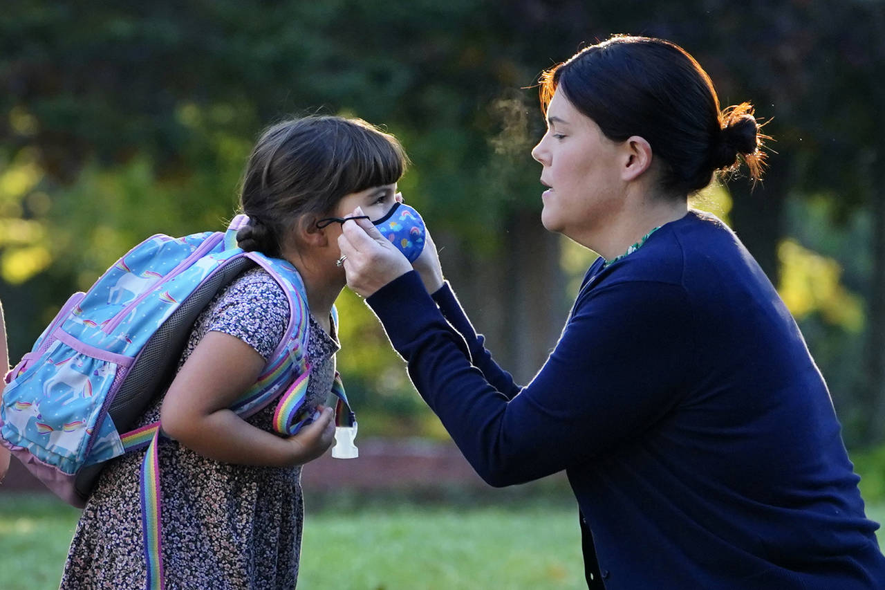 Sarah Staffiere adjusts a face covering on her daughter, Natalie, before school, Thursday, Oct. 7, ...