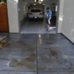 
              Matthew Landry wrings out a mop as he dries out his garage on C Street in San Rafael, Calif., on Monday, Oct. 25, 2021. Landry says shoes were floating in his garage when his street flooded during Saturday's storm. (Alan Dep/Marin Independent Journal via AP)
            