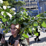 
              A woman carries branches as she participates in a climate march in Brussels, Sunday, Oct. 10, 2021. Some 80 organizations are joining in a climate march through Brussels to demand change and push politicians to effective action in Glasgow later this month.(AP Photo/Geert Vanden Wijngaert)
            
