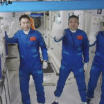 
              In this photo released by Xinhua News Agency, screen image captured at Beijing Aerospace Control Center in Beijing, China, Saturday, Oct. 16, 2021 shows three Chinese astronauts, from left, Ye Guangfu, Zhai Zhigang and Wang Yaping waving after entering the space station core module Tianhe. China's Shenzhou-13 spacecraft carrying three Chinese astronauts on Saturday docked at its space station, kicking off a record-setting six-month stay as the country moves toward completing the new orbiting outpost. Chinese characters,  left, read "Platform Camera B." (Tian Dingyu/Xinhua via AP)
            