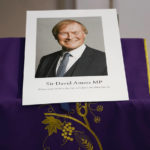 
              FILE - In this Oct. 15, 2021 file photo, an image of murdered British Conservative lawmaker David Amess is displayed near the altar in St Peters Catholic Church before a vigil in Leigh-on-Sea, Essex, England. The killing of British lawmaker Amess is once again fueling concern about a government program that tries to prevent at-risk young people from becoming radicalized, with critics saying the strategy is falling short and unfairly targets Muslim communities. (AP Photo/Alberto Pezzali, file)
            