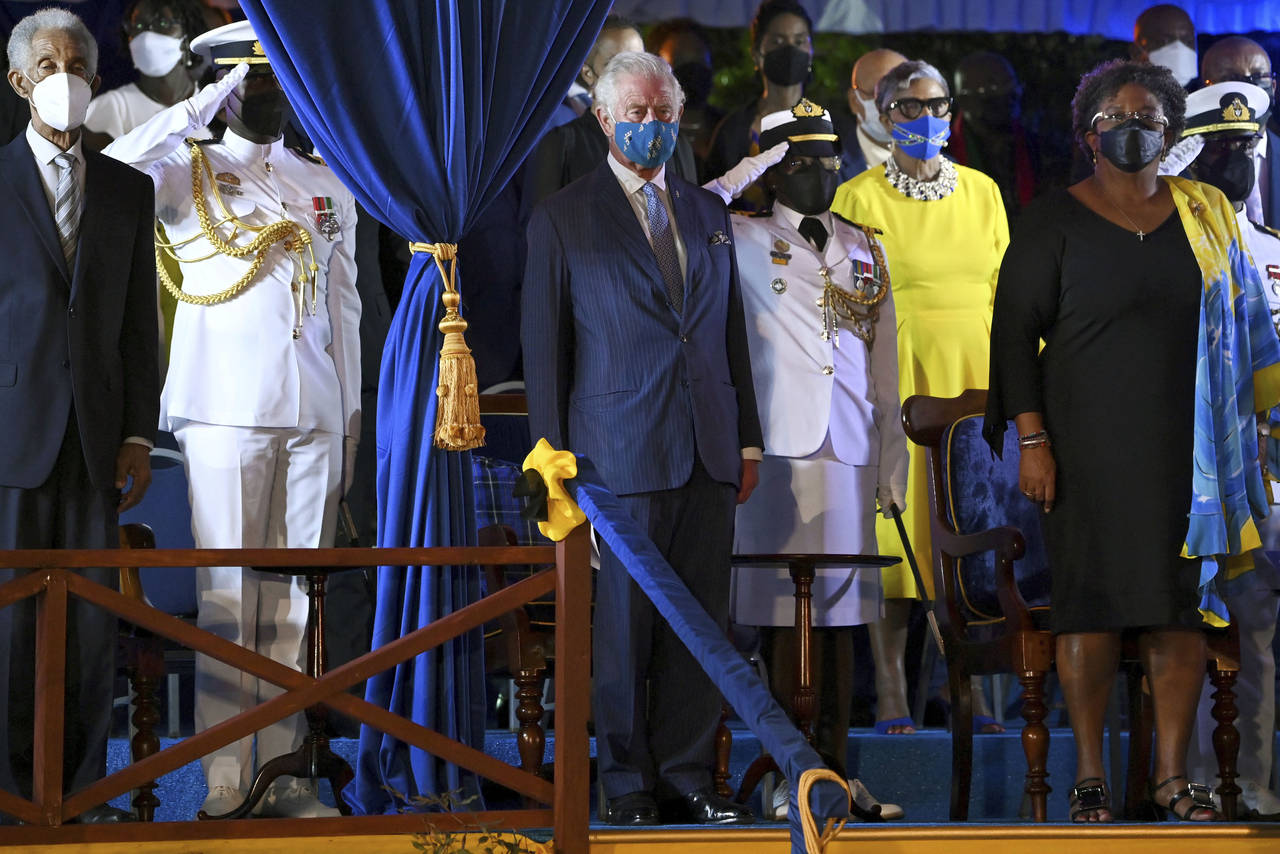 Britain's Prince Charles, centre, stands with Barbados Prime Minister Mia Mottley, right, and forme...