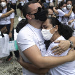 
              Caio Fonseca, who said his father died from complications related to COVID-19, cries and hugs his mother Roseli Fonsceca during a protest against the way the government handled the nation's response to the pandemic, organized by the "Widows of COVID" group on the Day of the Dead in Rio de Janeiro, Brazil, Tuesday, Nov. 2, 2021. (AP Photo/Bruna Prado)
            