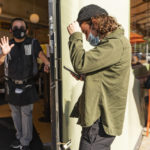 
              Waiter Juan Rodrigues, left, asks a customer to show his vaccination card before being allowed to sit inside the Fred 62 restaurant in the Los Feliz neighborhood of Los Angeles, Monday, Nov. 29, 2021. Enforcement began Monday in Los Angeles for one of the strictest vaccine mandates in the country, a sweeping measure that requires proof of COVID-19 shots for everyone entering a wide variety of businesses from restaurants to theaters and gyms to nail and hair salons. (AP Photo/Damian Dovarganes)
            