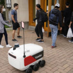 
              A food delivery robot stops outside a building in Ann Arbor, Mich. on Thursday, Oct. 7, 2021. Robot food delivery is no longer the stuff of science fiction. Hundreds of little robots __ knee-high and able to hold around four large pizzas __ are now navigating college campuses and even some city sidewalks in the U.S., the U.K. and elsewhere. While robots were being tested in limited numbers before the coronavirus hit, the companies building them say pandemic-related labor shortages and a growing preference for contactless delivery have accelerated their deployment. (AP Photo/Carlos Osorio)
            