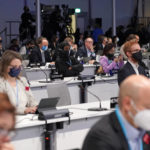 
              Delegates listen to speech of Britain's Chancellor of the Exchequer Rishi Sunak at the COP26 U.N. Climate Summit in Glasgow, Scotland, Wednesday, Nov. 3, 2021. The British government plans to make the U.K. "the world's first net-zero aligned financial center" as companies and investors seek to profit from the drive to build a low-carbon economy. Sunak will lay out the government's plans during a speech Wednesday as top financial officials from around the world meet at the U.N. climate conference in Glasgow, Scotland. (AP Photo/Alberto Pezzali)
            