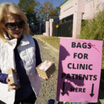 
              An anti-abortion advocate shows off a pair of hand woven baby "booties" offered women entering the Jackson Women's Health Organization, a state-licensed abortion clinic in Jackson, Miss., Tuesday, Nov. 30, 2021. The advocate hopes the booties remind those entering the clinic about babies and would make them reconsider receiving an abortion. On Wednesday, the U.S. Supreme Court will hear a case that directly challenges the constitutional right to an abortion established nearly 50 years ago. (AP Photo/Rogelio V. Solis)
            