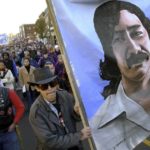 
              FILE - Marchers carry a large painting of jailed American Indian Leonard Peltier during a march for the National Day of Mourning in Plymouth, Mass., on Nov. 22, 2001. Denouncing centuries of racism and mistreatment of Indigenous people, members of Native American tribes from around New England will gather on Thanksgiving 2021 for a solemn National Day of Mourning observance. (AP Photo/Steven Senne, File)
            