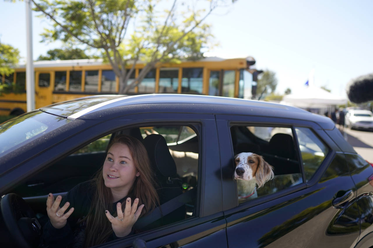 Brooklyn Pittman talks as she sits in her car with her dogs after receiving food from an Armed Serv...