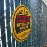 
              A warning sign marks a natural gas pipeline outside a compressor station on Monday, Oct. 25, 2021, in Dalworthington Gardens, Texas, a small municipality that's tucked within the city of Arlington. Compressor stations like this one change the pressure of the natural gas to help move it through the lines. Increasingly, natural gas ends up at facilities on the Gulf Coast where it is converted into liquid natural gas, or LNG, so it can be shipped to Europe, Asia and other parts of the world. Natural gas is used to heat homes and for cooking, among other things. (AP Photo/Martha Irvine)
            