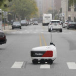 
              A food delivery robot crosses a street in Ann Arbor, Mich. on Thursday, Oct. 7, 2021. Robot food delivery is no longer the stuff of science fiction. Hundreds of little robots __ knee-high and able to hold around four large pizzas __ are now navigating college campuses and even some city sidewalks in the U.S., the U.K. and elsewhere. While robots were being tested in limited numbers before the coronavirus hit, the companies building them say pandemic-related labor shortages and a growing preference for contactless delivery have accelerated their deployment. (AP Photo/Carlos Osorio)
            