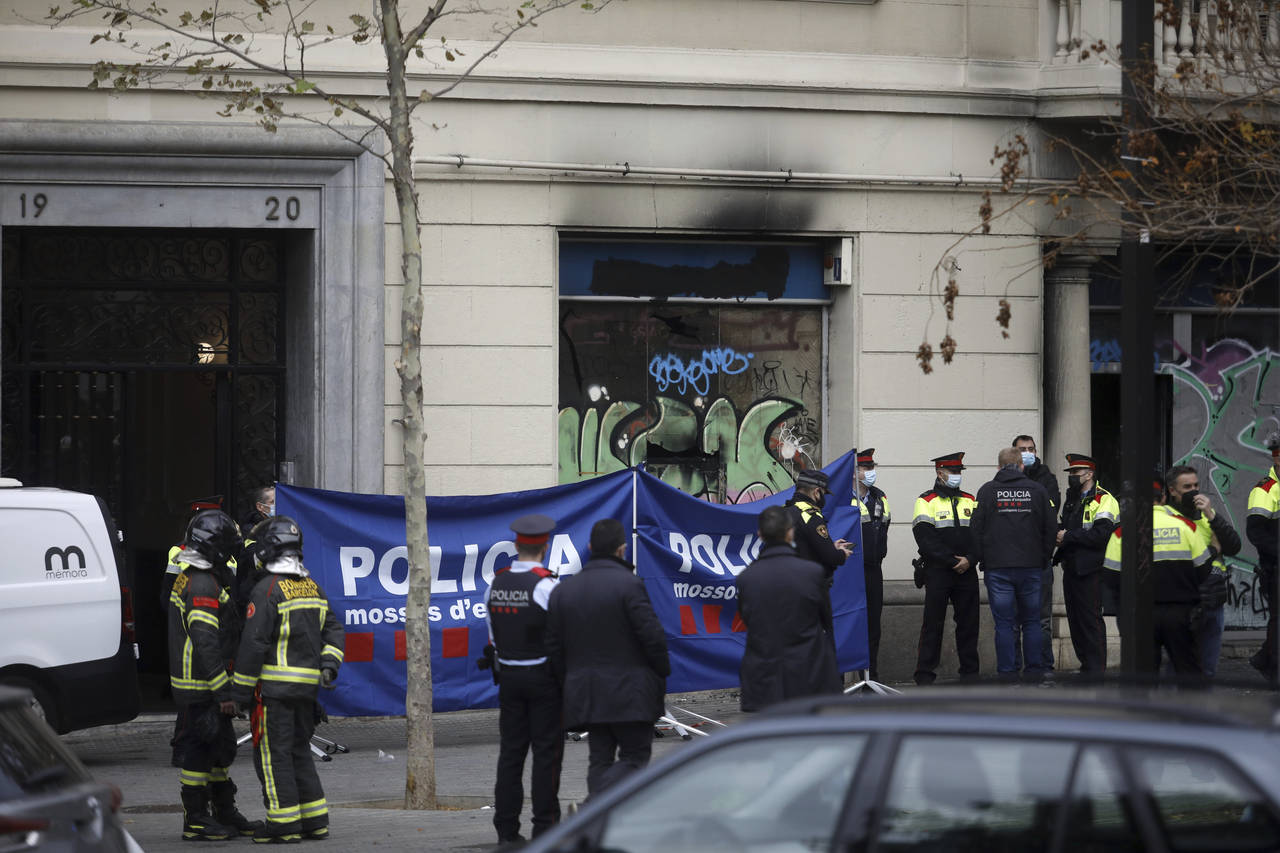 Policemen and firefighters work at the scene where a fire broke out in a building, in Barcelona, Sp...