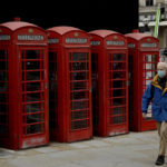 
              FILE - A man wearing a face mask walks past traditional red phone boxes, in London, on Nov. 20, 2020. Thousands of Britain’s iconic red phone boxes will be protected from removal under new rules, the telecoms regulator said Tuesday, Nov. 9, 2021. The public payphone boxes may appear obsolete relics to many in an age of smart mobile phones, but the telecoms regulator, Ofcom, said they can still be a “lifeline” for people in need. The regulator is proposing rules to prevent 5,000 phone boxes in areas with poor mobile coverage from being closed down. It said that phone boxes in areas considered an accident or suicide hotspot, and those which have had more than 52 calls made from them in the past 12 months, would also meet the criteria. (AP Photo/Matt Dunham, FILE)
            