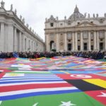 
              Members of a migrants association hold a huge banner made with World's flags as Pope Francis delivers the Angelus prayer in St. Peter's Square at the Vatican, Sunday, Nov. 28, 2021.(AP Photo/Gregorio Borgia)
            