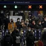 
              Commuters walk through ticket barriers in Waterloo train station, London, after disembarking from a train, Monday, Nov. 29, 2021. The new potentially more contagious omicron variant of the coronavirus popped up in more European countries on Saturday, just days after being identified in South Africa, leaving governments around the world scrambling to stop the spread. In Britain, Prime Minister Boris Johnson said mask-wearing in shops and on public transport will be required, starting Tuesday. (AP Photo/Matt Dunham)
            