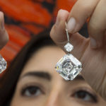 
              A Sotheby's employee holds a pair of diamond earrings weighing 25.88 carats, estimated to sell between 4'100'000 - 5'000'000 Swiss francs, during a preview at Sotheby's before auction sale, in Geneva, Switzerland, Tuesday, Nov. 2, 2021. (Salvatore Di Nolfi/Keystone via AP)
            