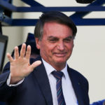 
              Brazilian President Jair Bolsonaro waves to supporters outside a convention center in Brasilia, Brazil, Tuesday, Nov. 30, 2021, after attending a ceremony where he officially joined the centrist Liberal Party. (AP Photo/Raul Spinasse)
            