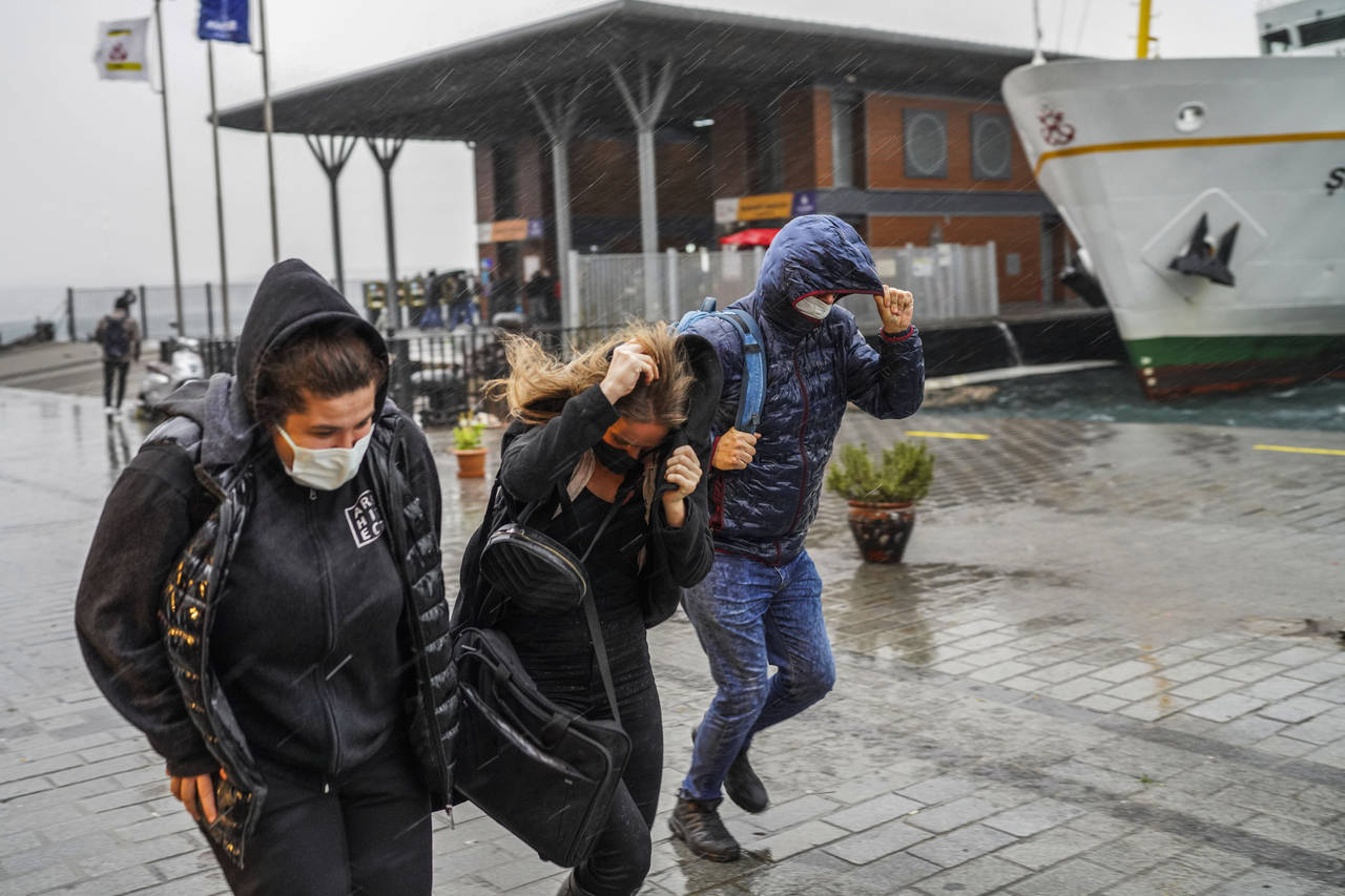 People run under a heavy rain during a stormy day in Istanbul, Turkey, Monday, Nov. 29, 2021. A pow...