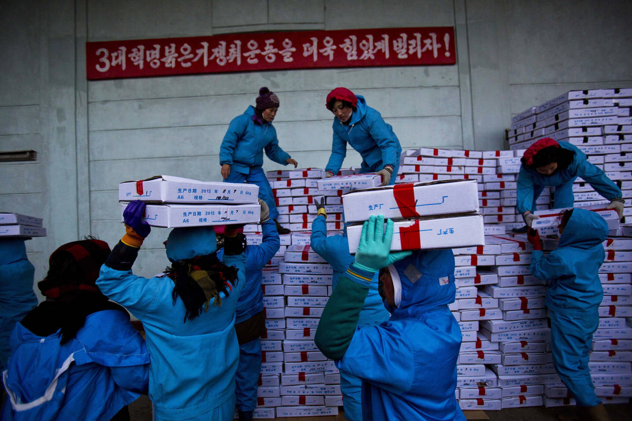 FILE - Workers carry boxes of seafood on Nov. 8, 2013, as they load a Chinese transport truck at th...