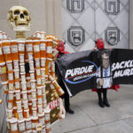 
              Pill Mann" made by Frank Huntley of Worcester, Mass., from his opioid prescription pill bottles, is displayed during a protest by advocates for opioid victims outside the Department of Justice, Friday, Dec. 3, 2021, in Washington. A federal judge has rejected OxyContin maker Purdue Pharma’s sweeping deal to settle thousands of lawsuits over the toll of opioids. U.S. District Court Judge Colleen McMahon in New York found flaws in the way the bankruptcy settlement protects members of the Sackler family who own the company from lawsuits. (AP Photo/Carolyn Kaster)
            