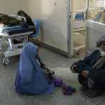 
              A woman holds her child while sitting on the floor of the emergency ward of the Indira Gandhi Children's Hospital in Kabul, Afghanistan, on Wednesday, Dec. 8, 2021. Afghanistan's health care system, is on the brink of collapse and to function only with a lifeline from aid organisations. (AP Photo/Petros Giannakouris)
            