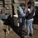 
              Mariela Perez, left, is comforted by a neighbor during the wake of her husband Daniel Arnulfo Perez Uxla, 41, in El Tejar, Guatemala, Sunday, Dec. 19, 2021. Perez Uxla was one of the fifty-six people  killed when a truck carrying Central American migrants rolled over on a highway in Tuxtla, Mexico on Dec. 9. (AP Photo/Moises Castillo)
            