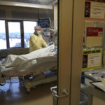 
              Steve Grove, a chaplain at Hennepin County Medical Center, prays in a COVID-19 patient's room, Friday, Dec. 10, 2021, in Minneapolis. He acknowledged that he sometimes gets mad at unvaccinated patients because it "didn’t have to be this way. And now there’s a mess that perhaps was avoidable.” (AP Photo/Charlie Neibergall)
            