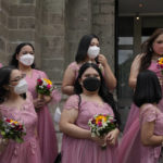 
              Women wearing face masks wait for the groom and bride during a wedding ceremony outside Manila's Cathedral, Philippines on Thursday, Dec. 2, 2021. Religious activities, including weddings, have resumed with greater capacity as the government continues to ease health restrictions due to the decline of COVID-19 cases in the country while closely monitoring the new omicron virus variant. (AP Photo/Aaron Favila)
            