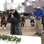 
              People offer flowers for the victims of a resettlement program led by North Korea, at a commemoration ceremony held at a port in Niigata, Japan on Dec. 14, 2021. Some 93,000 ethnic Korean residents in Japan and their relatives joined the program only to find the opposite of what was promised. Most were put to brutal manual labor at mines, in forests and on farms and faced discrimination because of Japan's past colonization of the Korean Peninsula. (AP Photo/Chisato Tanaka)
            