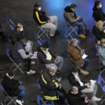 
              People wait after they received COVID-19 vaccine at the National Velodrome in Saint-Quentin-en-Yvelines, west of Paris, France, Friday, Dec. 17, 2021. The government is holding a special virus security meeting Friday to address growing pressure on hospitals in France from rising infections. (AP Photo/Christophe Ena)
            