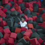 
              A child is surrounded by sponge cushions as she plays at a Johannesburg shopping mall Friday, Dec. 17, 2021. (AP Photo/Denis Farrell)
            