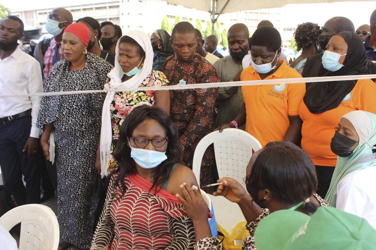 A Nigeria civil servant receives a dose of the AstraZeneca coronavirus vaccine, before she is allow...