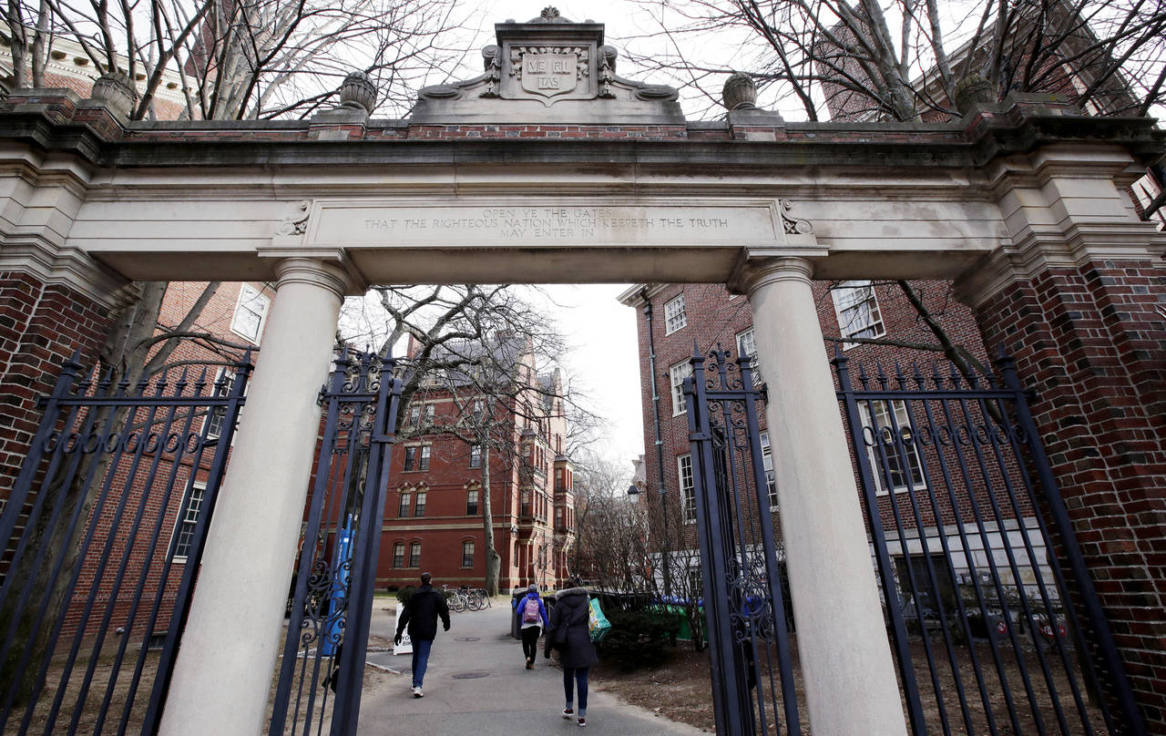 FILE - People walk through the gates leading to Harvard Yard, Dec. 13, 2018, at Harvard University ...
