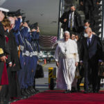 
              Pope Francis, flanked by Greek Foreign Minister Nikos Dendias arrives at the Eleftherios Venizelos International Airport in Athens, Greece, Saturday, Dec. 4, 2021. Pope Francis arrived to Greece Saturday for the second leg of his trip to the region with meetings in Athens aimed at bolstering recently-mended ties between the Vatican and Orthodox churches. (AP Photo/Alessandra Tarantino)
            