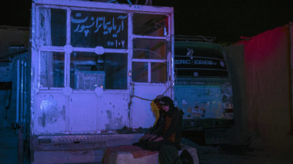 Two Afghan men pray at a bus station in Herat, Afghanistan, on Tuesday, Nov. 23, 2021, before they ...