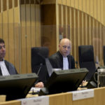 
              Presiding judge Hendrik Steenhuis, center, during the ongoing trial and criminal proceedings regarding the downing of Malaysia Airlines flight MH17, at the high security court at Schiphol airport, near Amsterdam, Netherlands, Monday Dec. 20, 2021. Prosecutors are scheduled to begin explaining evidence and their case to judges Monday in the murder trial of three Russians and a Ukrainian charged with involvement in downing Malaysia Airlines flight MH17 over eastern Ukraine in 2014, killing all 298 passengers and crew. (AP Photo/Peter Dejong)
            